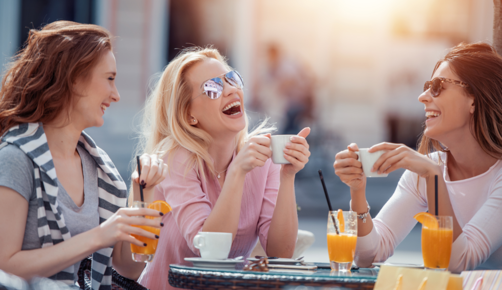 Frauen unterhalten sich in einem gemütlichen Café bei Kaffee – eine Szene, die soziale Verbundenheit, Vertrauen und echte Nähe im Alltag zeigt.